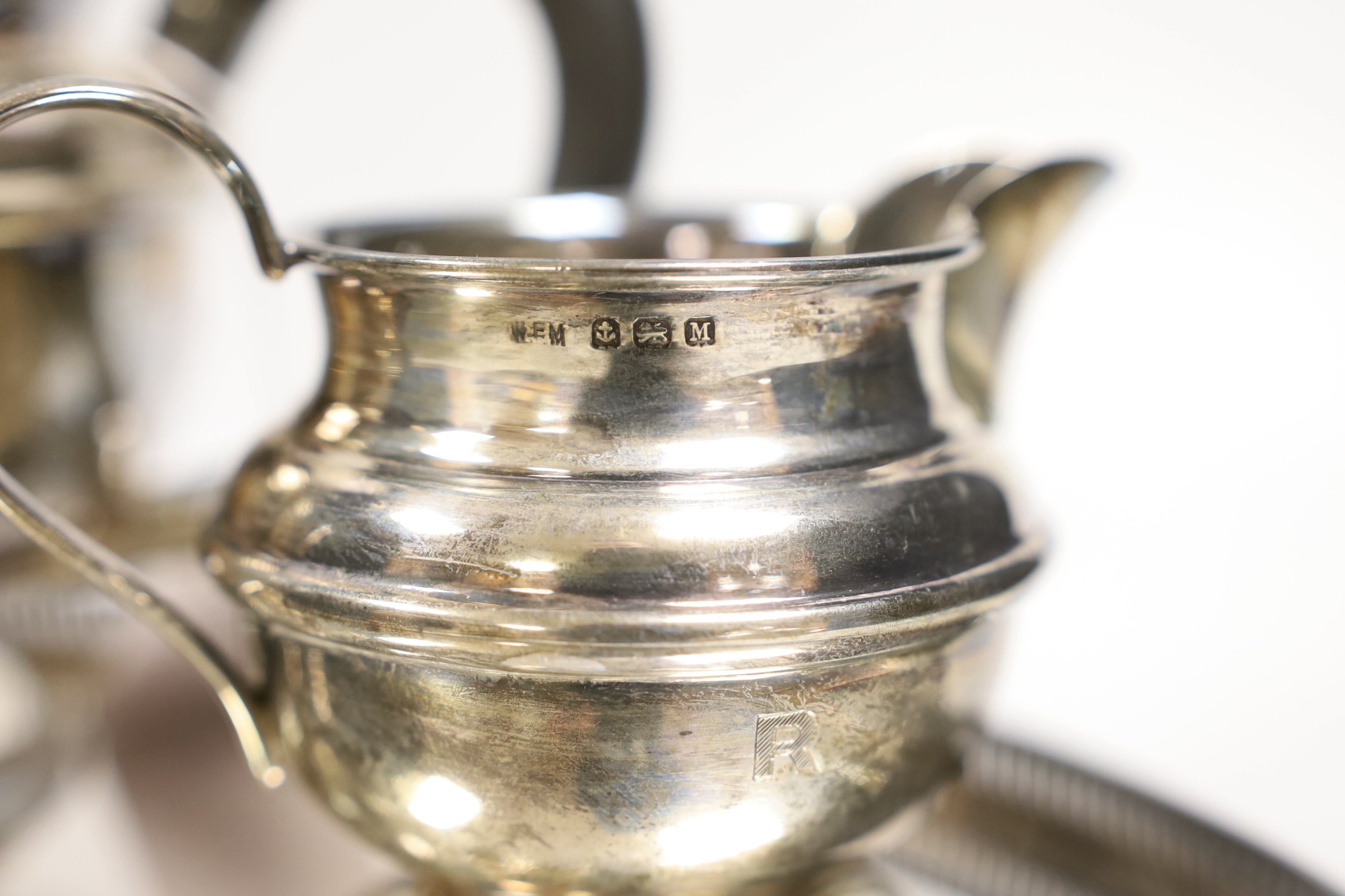 A George VI silver three-piece tea set, with engraved inscription, W.F. Mitchell, Birmingham, 1936, gross weight 22oz and a plated two handled tea tray, 49.3cm.